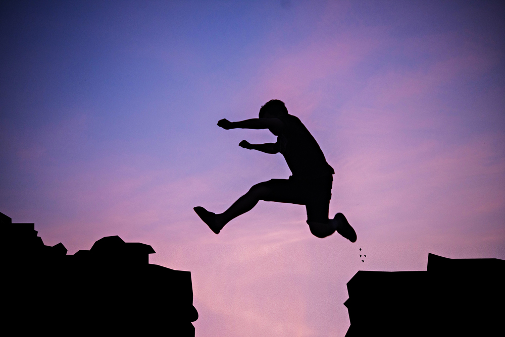 Man jumping over cliff financial goals 2019